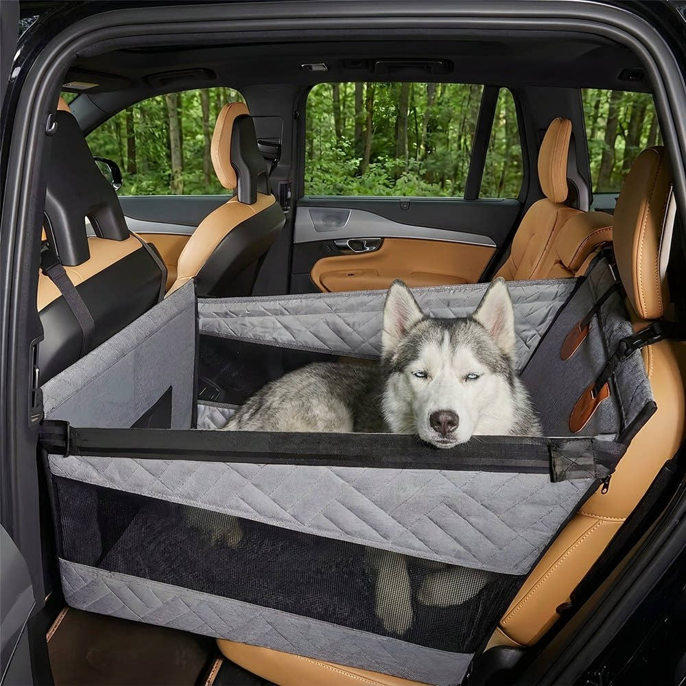 Husky allongé dans le panier de voiture pour chien Yzavo, la tête posée sur le rebord
