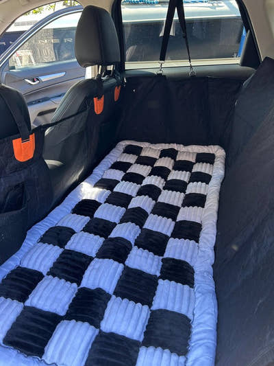 Tapis damier posé sur une housse à l'arrière de la voiture