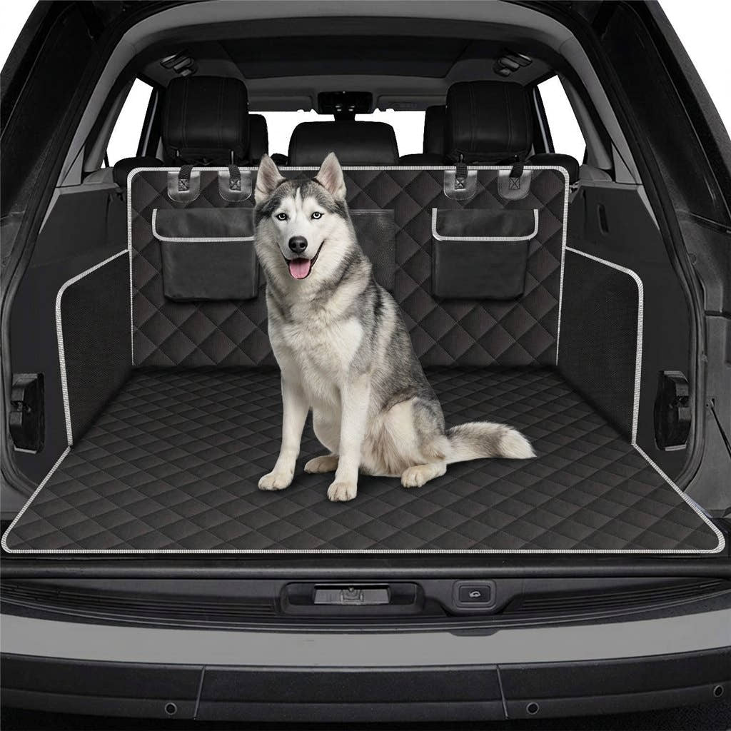Le même husky assis dans le coffre protégé par la housse de coffre Yzavo