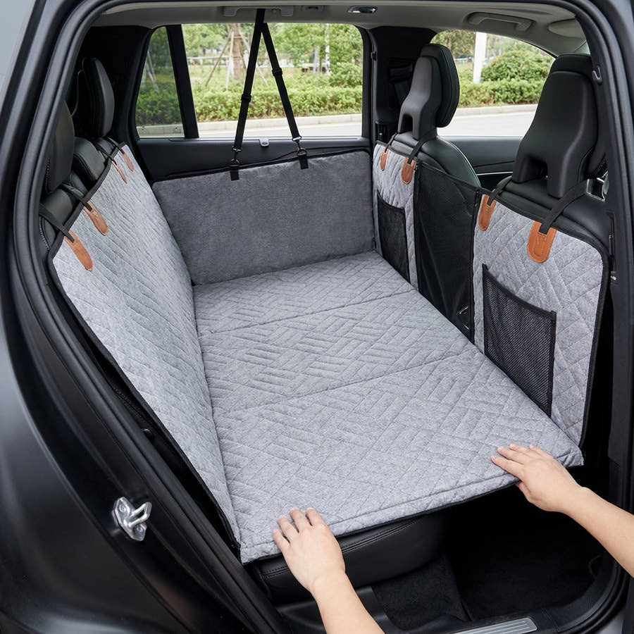 Main dépliant le fond rigide de la housse Yzavo au-dessus de l'espace pour les jambes