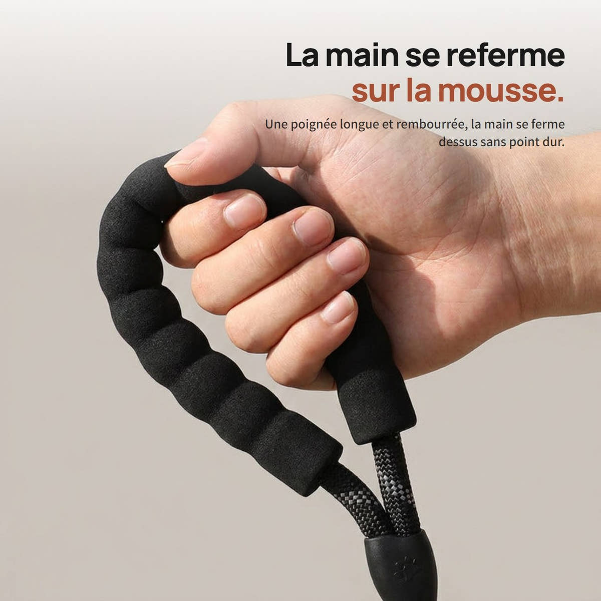 Main refermée sur la poignée rembourrée de la laisse pour chien Yzavo
